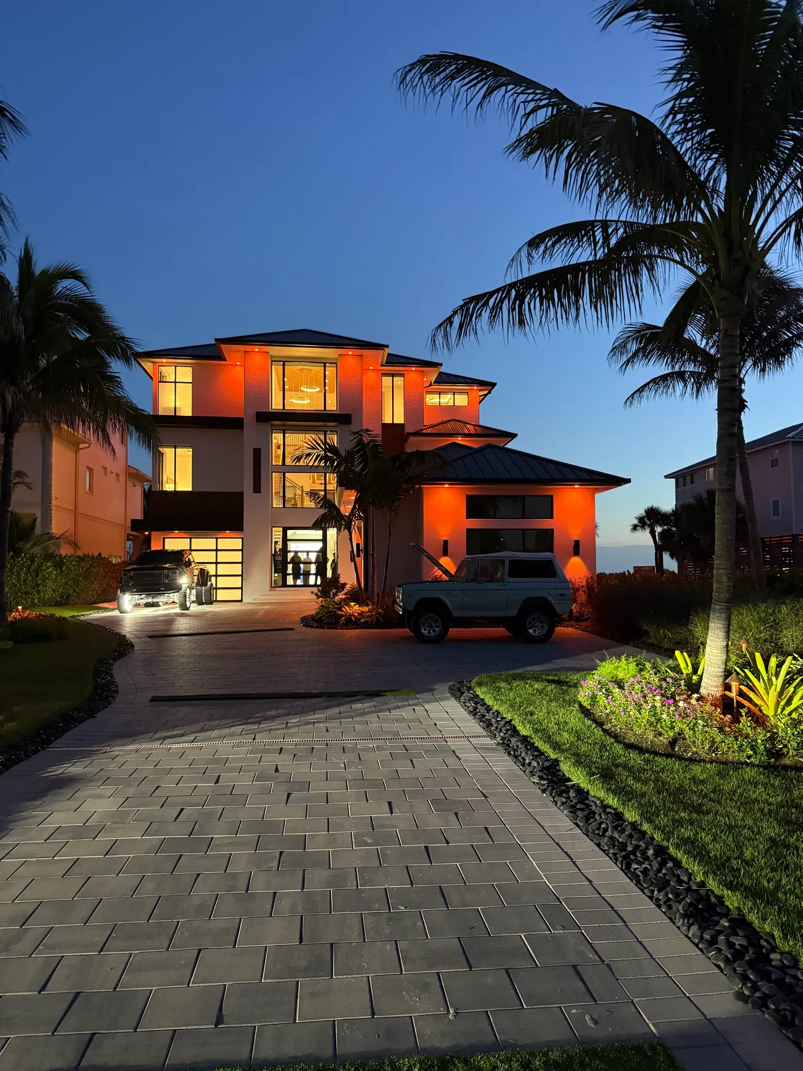 Palm-lined entry and driveway illuminated after dark
